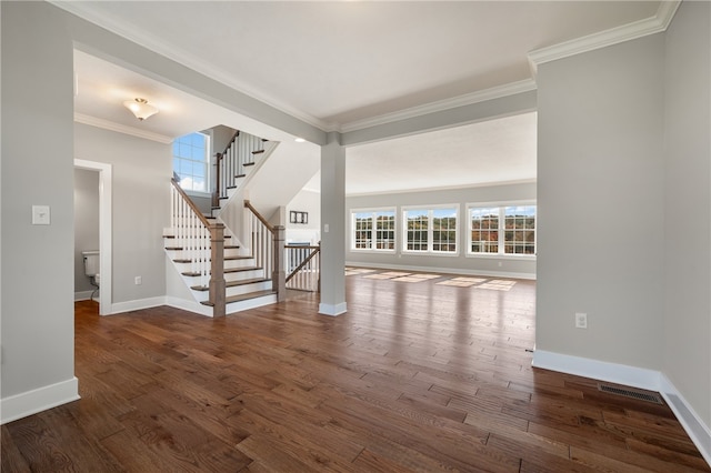 unfurnished living room featuring ornamental molding, dark wood-type flooring, and a wealth of natural light