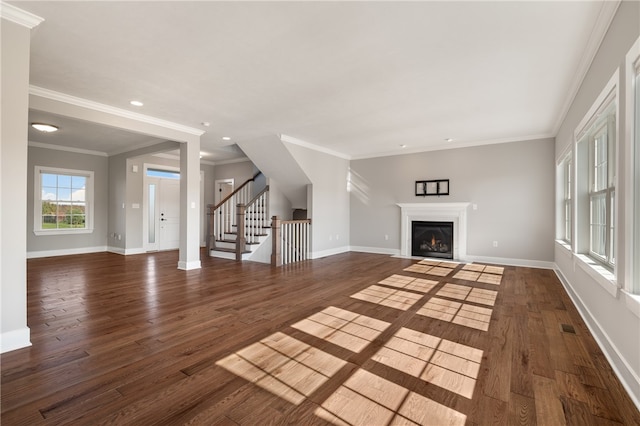 unfurnished living room featuring dark wood-type flooring and crown molding