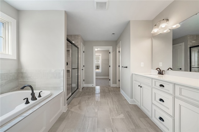 bathroom with vanity and independent shower and bath