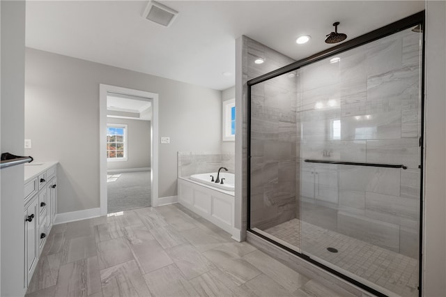 bathroom with vanity and shower with separate bathtub