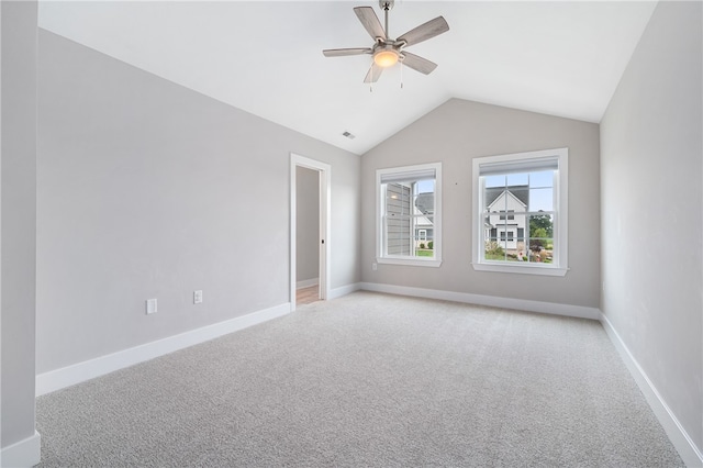 carpeted spare room with ceiling fan and vaulted ceiling