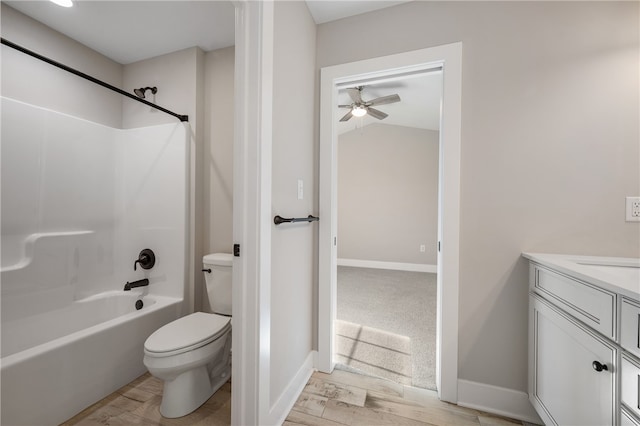 full bathroom featuring ceiling fan, hardwood / wood-style flooring, toilet, vanity, and washtub / shower combination