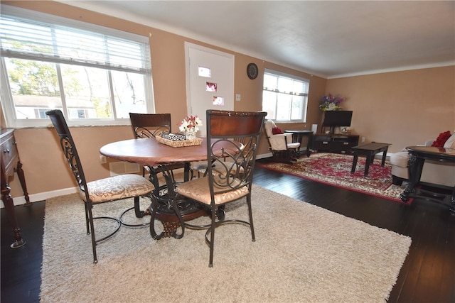 dining space featuring dark wood-type flooring and plenty of natural light