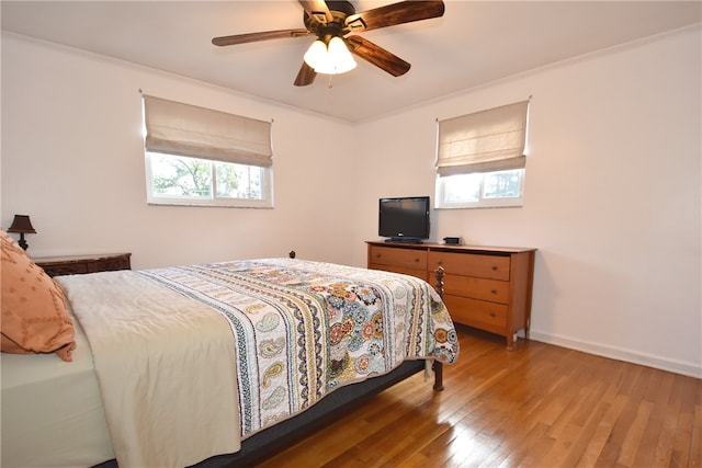 bedroom featuring ceiling fan, crown molding, and dark hardwood / wood-style floors