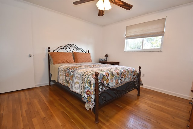 bedroom featuring ceiling fan, crown molding, and hardwood / wood-style floors