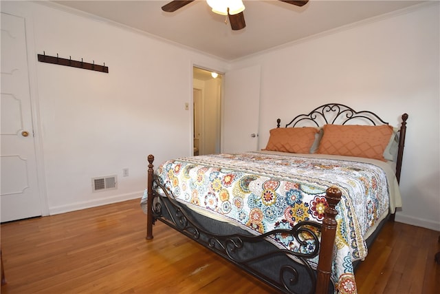 bedroom featuring ceiling fan, hardwood / wood-style flooring, and crown molding