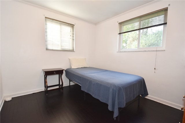 bedroom with ornamental molding, multiple windows, and dark hardwood / wood-style floors