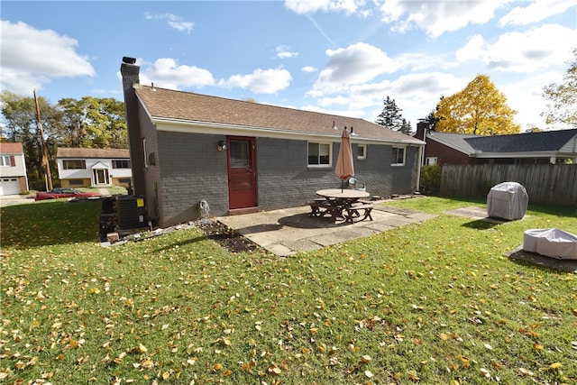 back of house with a patio, a yard, and central air condition unit