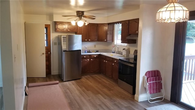 kitchen featuring ceiling fan, sink, stainless steel appliances, pendant lighting, and light wood-type flooring