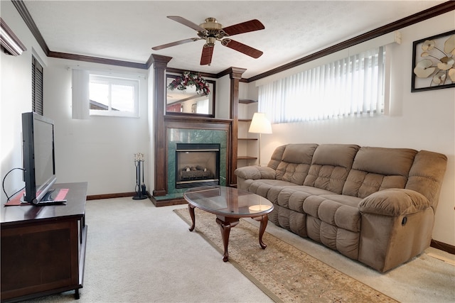 carpeted living room featuring ceiling fan, ornamental molding, a wealth of natural light, and a premium fireplace