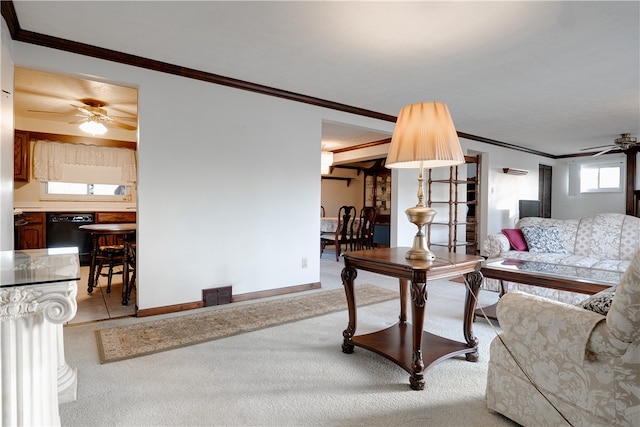 carpeted living room with ornamental molding and ceiling fan