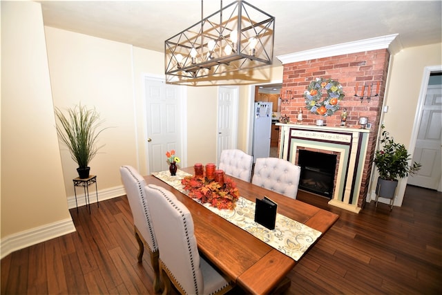 dining space with a notable chandelier, a fireplace, ornamental molding, and dark wood-type flooring