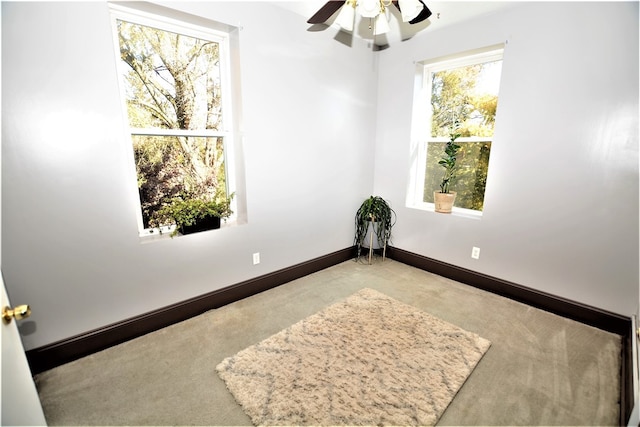 carpeted spare room featuring ceiling fan