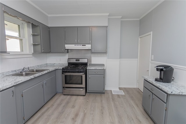 kitchen featuring sink, stainless steel range with gas stovetop, gray cabinets, ornamental molding, and light hardwood / wood-style flooring