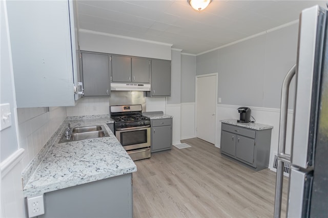 kitchen with sink, light hardwood / wood-style floors, gray cabinets, stainless steel gas range, and white refrigerator