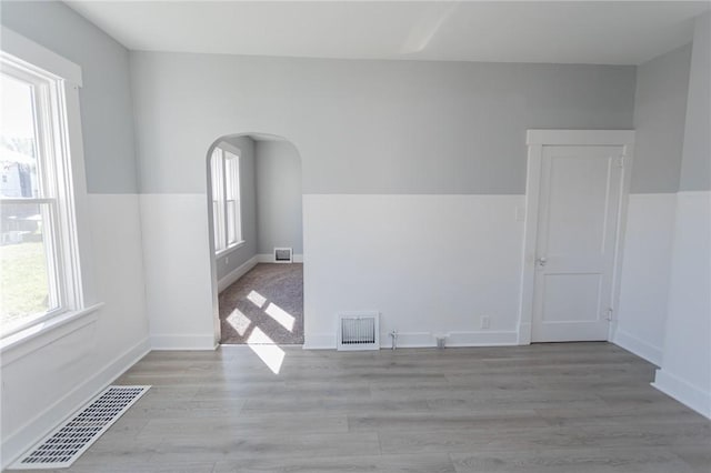 205 Woodlawn Ave, Connellsville, PA 15425 - empty room featuring healthy amount of natural light, arched walkways, light wood-style floors, and baseboards