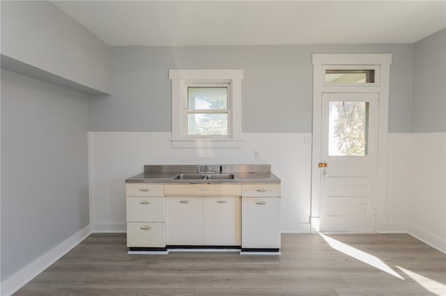 kitchen with a wealth of natural light, stainless steel counters, and light hardwood / wood-style floors