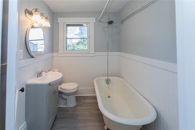 bathroom featuring vanity, hardwood / wood-style floors, toilet, and a washtub