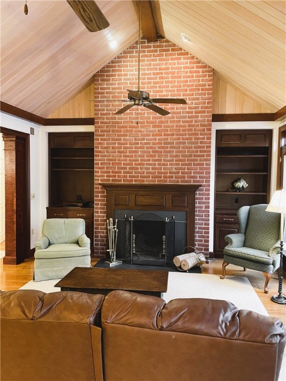 living room featuring vaulted ceiling with beams, a fireplace, wood ceiling, built in features, and light hardwood / wood-style flooring