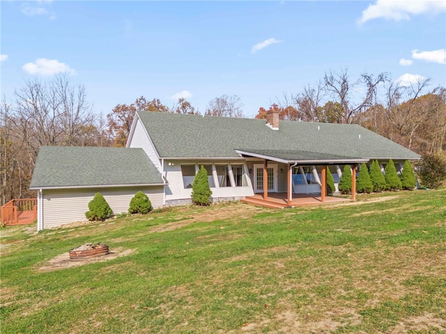 view of front of home featuring a front lawn, a fire pit, and a deck