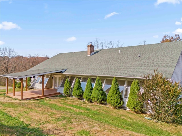 rear view of property featuring a lawn