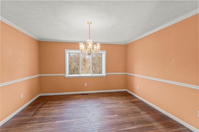 unfurnished room with dark hardwood / wood-style flooring, an inviting chandelier, and crown molding