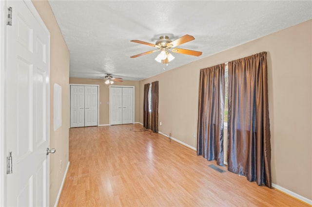 spare room featuring a textured ceiling, light wood-type flooring, and ceiling fan