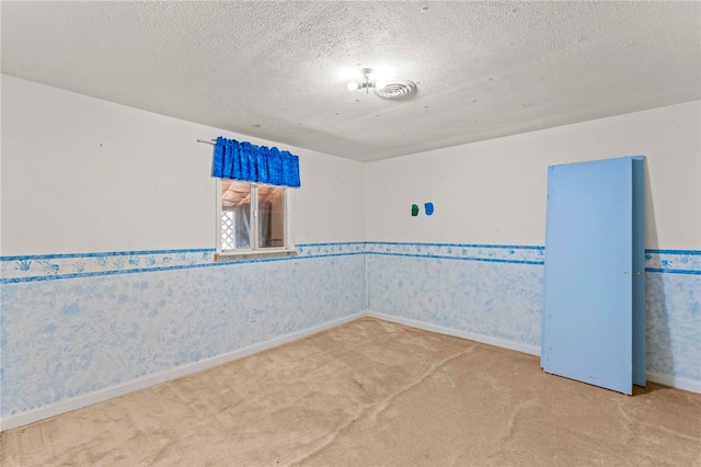 unfurnished room featuring carpet flooring and a textured ceiling