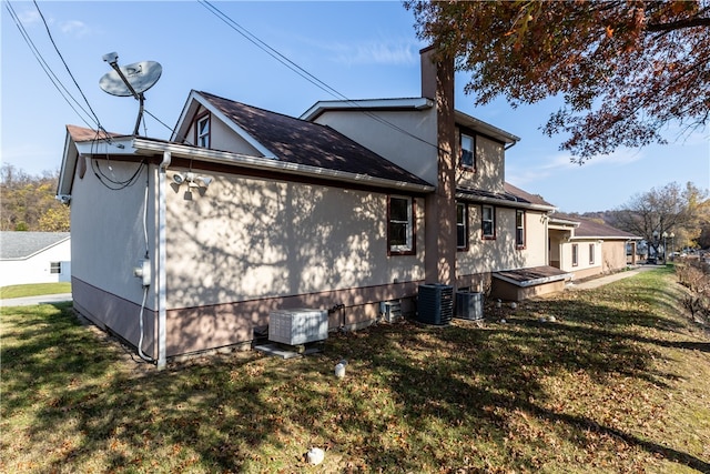 view of side of home with central air condition unit and a yard