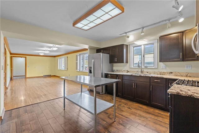 kitchen with sink, track lighting, dark brown cabinetry, and hardwood / wood-style flooring