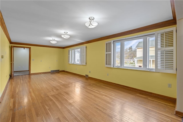 spare room with crown molding and light hardwood / wood-style flooring