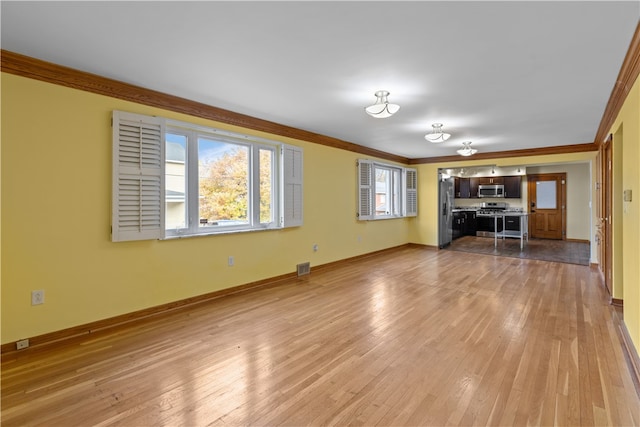 unfurnished living room with crown molding and light hardwood / wood-style floors