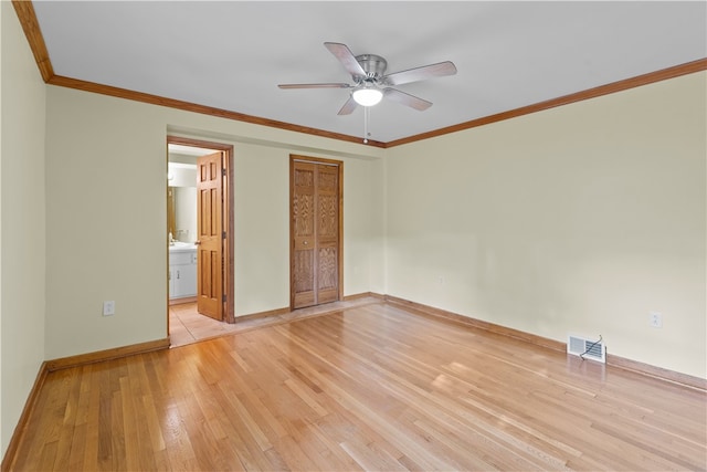 unfurnished bedroom featuring light hardwood / wood-style floors, crown molding, ensuite bath, and ceiling fan