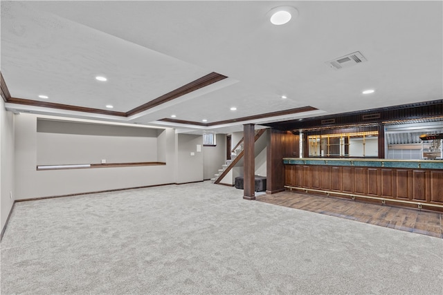 interior space with crown molding, light colored carpet, and a raised ceiling