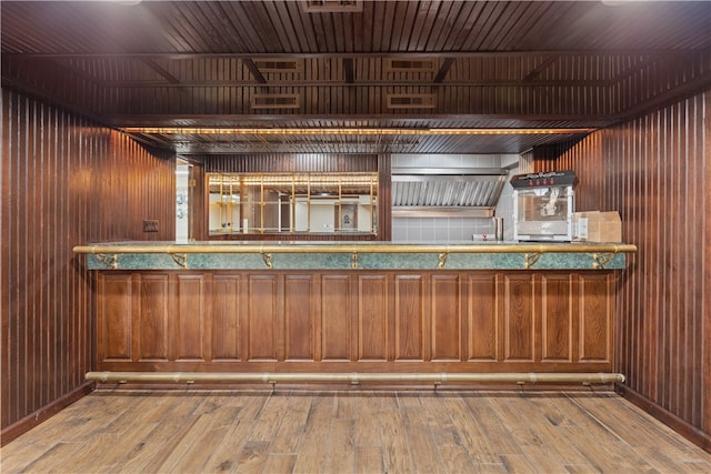 bar featuring wooden walls and wood-type flooring