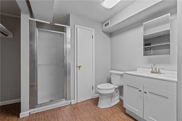 bathroom with a shower with door, a textured ceiling, wood-type flooring, toilet, and vanity