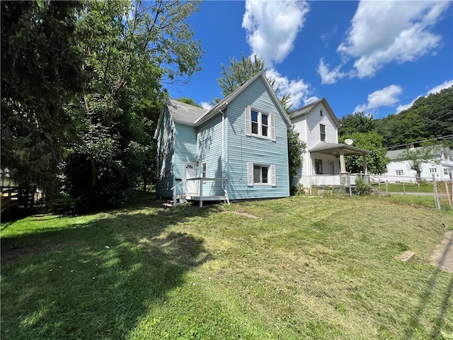 rear view of property featuring a lawn