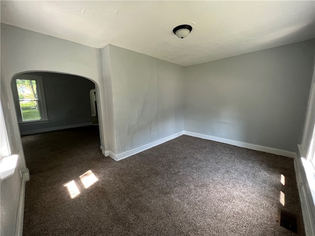 empty room featuring dark carpet