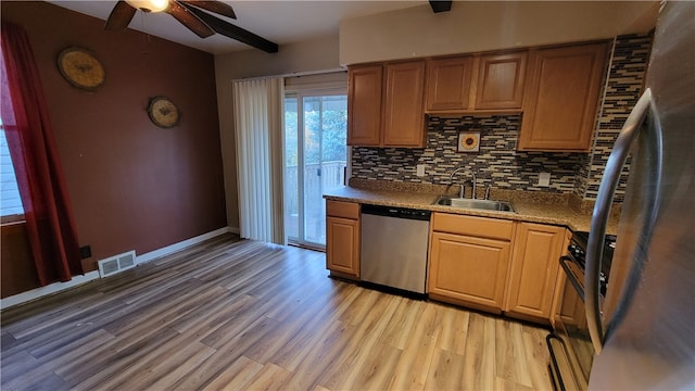 kitchen with sink, light hardwood / wood-style floors, stainless steel appliances, ceiling fan, and decorative backsplash