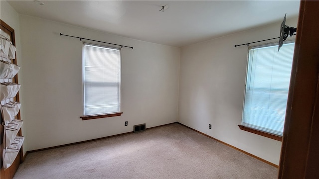 unfurnished room featuring light colored carpet