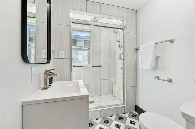 bathroom with vanity, toilet, and tiled shower