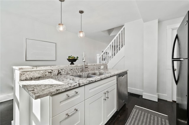 kitchen with light stone countertops, dishwasher, dark hardwood / wood-style flooring, pendant lighting, and white cabinets