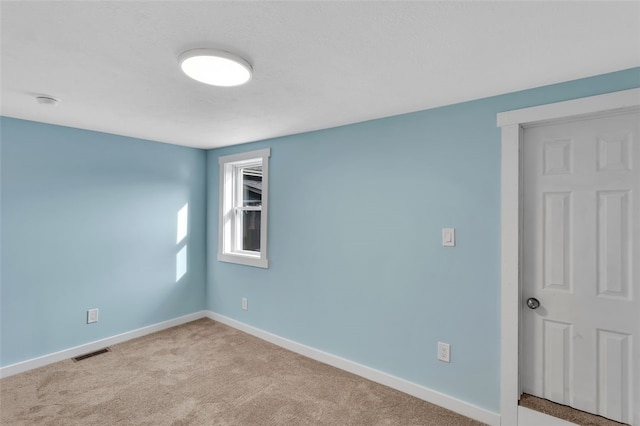 spare room featuring light colored carpet