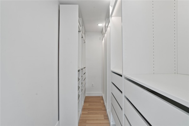 walk in closet with light hardwood / wood-style flooring