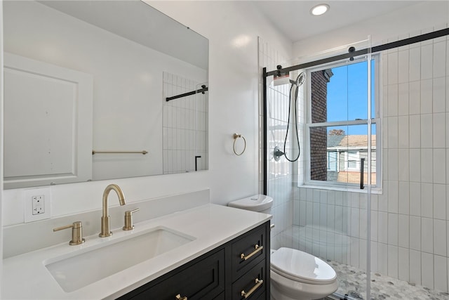 bathroom with toilet, a shower with shower door, and vanity