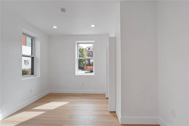 spare room with light wood-type flooring and a wealth of natural light