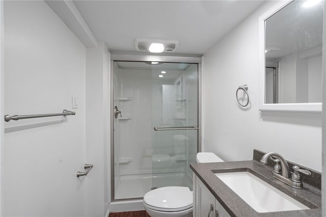 bathroom featuring vanity, toilet, and a shower with shower door