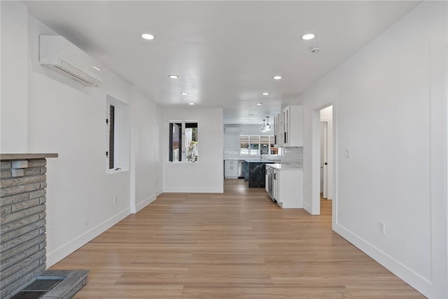 hallway featuring light hardwood / wood-style flooring and a wall mounted AC