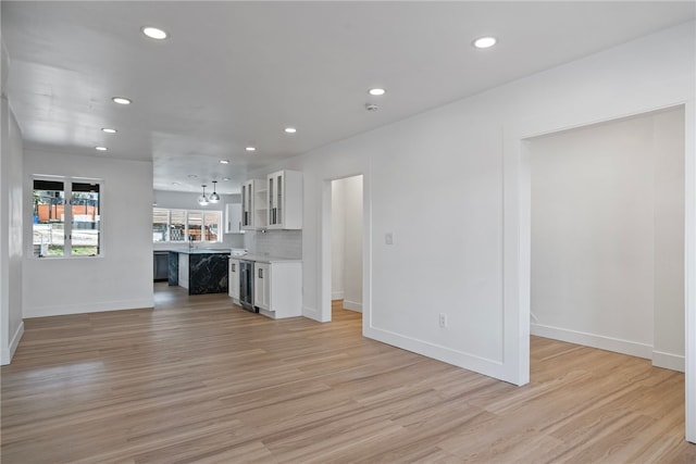 unfurnished living room with light hardwood / wood-style flooring and wine cooler