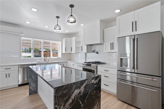 kitchen featuring a wall mounted AC, a kitchen island, white cabinetry, and stainless steel appliances